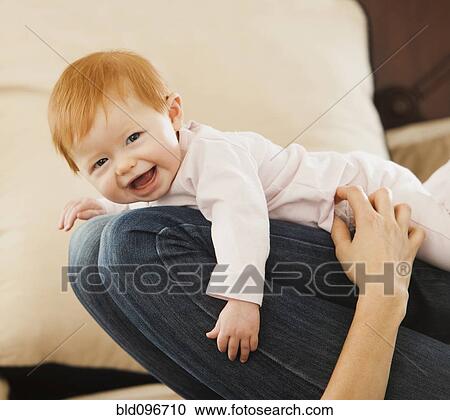 Stock Image - Caucasian mother playing with baby daughter. Fotosearch