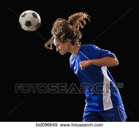 Stock Photo - Caucasian soccer player heading the ball. Fotosearch