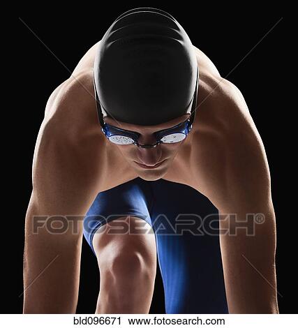 Stock Image - Caucasian teenage boy in swim cap and goggles. Fotosearch