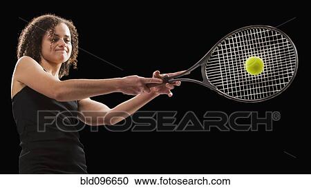 Stock Image - Caucasian tennis player hitting the tennis ball. Fotosearch