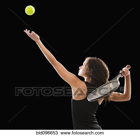 Stock Image - Caucasian tennis player serving the ball. Fotosearch