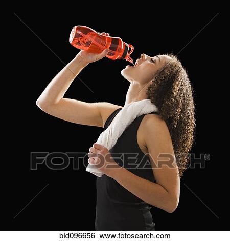 Stock Photograph - Caucasian woman drinking from water bottle. Fotosearch