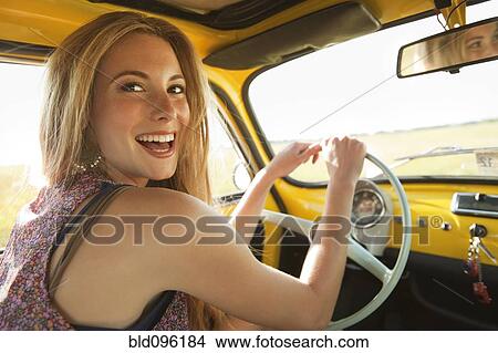 Picture - Caucasian woman driving old-fashioned car. Fotosearch