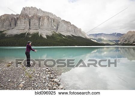 Stock Photography - Caucasian woman fishing in Maligne Lake. Fotosearch