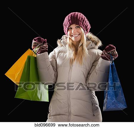 Caucasian woman in coat holding shopping bags View Large Photo Image Stock Photo - Caucasian woman in coat holding shopping bags. Fotosearch