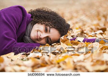 Caucasian woman laying in autumn leaves View Large Photo Image Picture - Caucasian woman laying in autumn leaves. Fotosearch