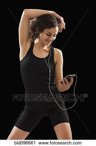 Stock Image - Caucasian woman listening to mp3 player. Fotosearch