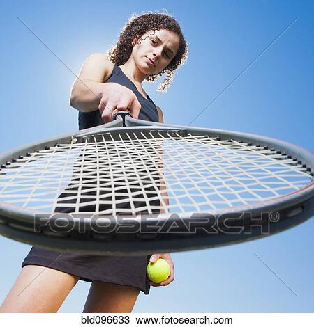 Stock Image - Caucasian woman playing tennis. Fotosearch