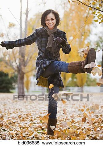 Stock Photography - Caucasian woman playing with autumn leaves. Fotosearch