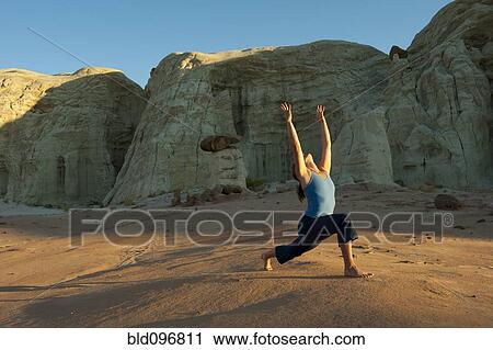 Stock Image - Caucasian woman practicing yoga in desert. Fotosearch