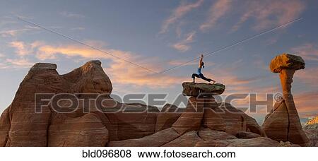 Stock Photo - Caucasian woman practicing yoga on top of rock formation. Fotosearch