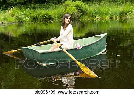 Caucasian woman rowing boat in pond View Large Photo Image Stock Photo - Caucasian woman rowing boat in pond. Fotosearch