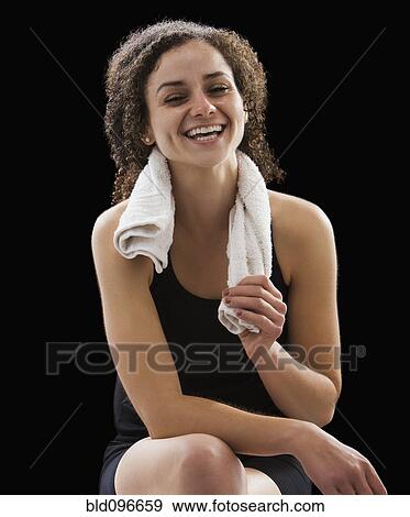 Stock Photo - Caucasian woman sitting with towel around her neck. Fotosearch