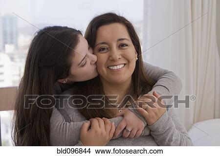 Picture - Chilean daughter kissing mother. Fotosearch