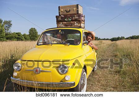 Stock Image - Couple in old-fashioned car on road trip. Fotosearch