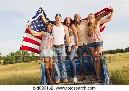 Friends holding American flag on back of truck View Large Photo Image Stock Image - Friends holding American flag on back of truck. Fotosearch