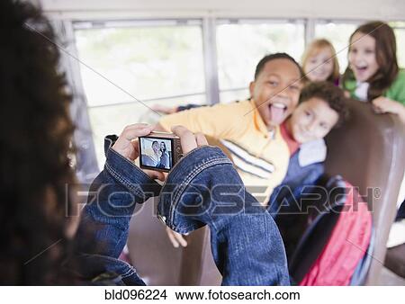 Girl taking photographs on school bus View Large Photo Image Picture - Girl taking photographs on school bus. Fotosearch