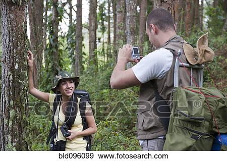 Stock Photo - Hispanic couple hiking and taking photographs. Fotosearch