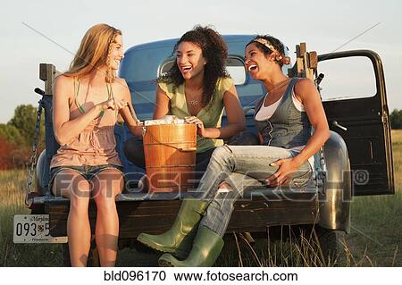 Laughing friends churning ice cream in back of truck View Large Photo Image Stock Image - Laughing friends churning ice cream in back of truck. Fotosearch