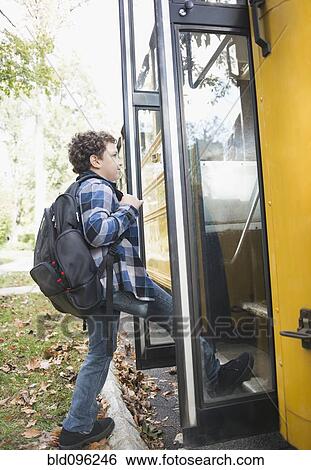 Stock Photograph - Mixed race boy getting onto school bus. Fotosearch