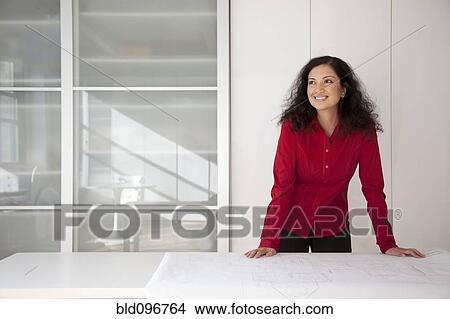 Picture - Mixed race businesswoman standing in office. Fotosearch