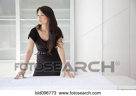 Stock Image - Mixed race businesswoman standing in office. Fotosearch