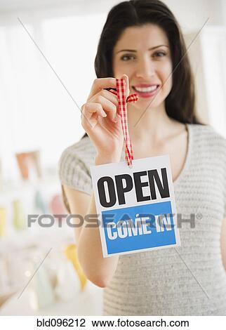 Mixed race woman holding shop open sign View Large Photo Image Stock Image - Mixed race woman holding shop open sign. Fotosearch