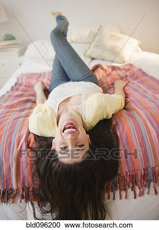 Mixed race woman laying on bed View Large Photo Image Stock Image - Mixed race woman laying on bed. Fotosearch