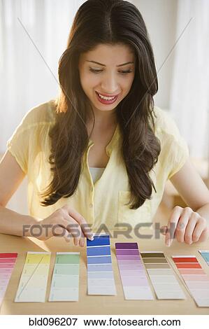 Mixed race woman looking at paint swatches View Large Photo Image Stock Photo - Mixed race woman looking at paint swatches. Fotosearch