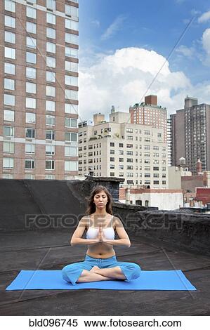 Mixed race woman practicing yoga on rooftop View Large Photo Image Stock Photography - Mixed race woman practicing yoga on rooftop. Fotosearch