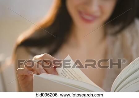 Stock Photograph - Mixed race woman reading book. Fotosearch