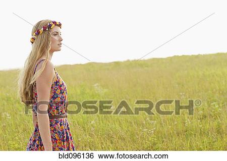 Stock Photograph - Tranquil Caucasian woman walking in field. Fotosearch
