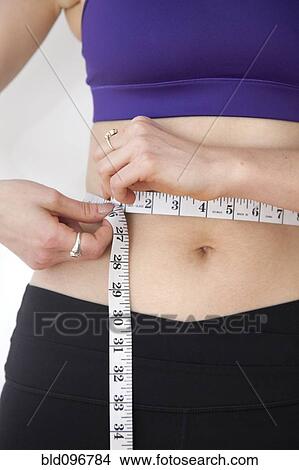 Picture - Woman measuring waistline. Fotosearch