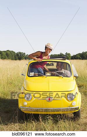 Woman standing in car sun roof in field View Large Photo Image Stock Image - Woman standing in car sun roof in field. Fotosearch