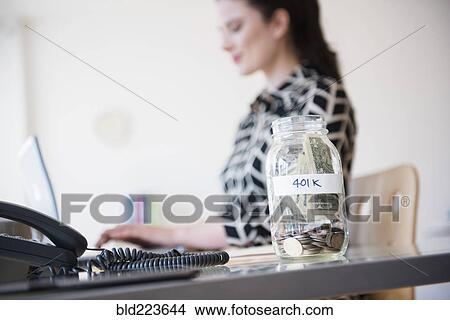 401k money jar on desk of Caucasian businesswoman View Large Photo Image Picture - 401k money jar on desk of Caucasian businesswoman. Fotosearch
