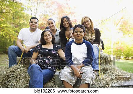 Stock Photograph - Adults and children sitting on hay ride. Fotosearch