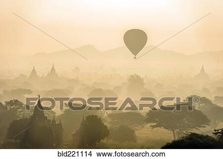 Picture - Aerial view of hot air balloons flying over towers. Fotosearch