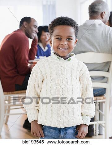 Stock Photography - African American boy smiling with family in background. Fotosearch