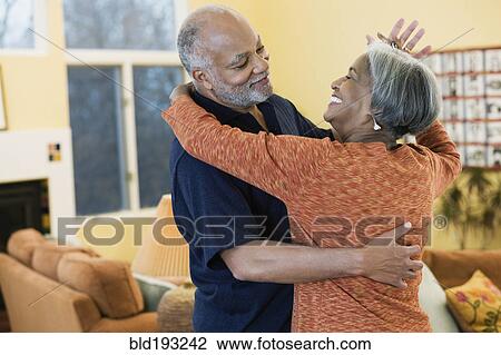 Stock Image - African American couple dancing in living room. Fotosearch