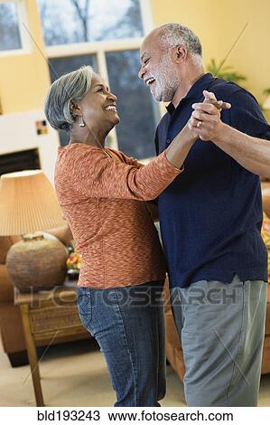 Stock Image - African American couple dancing in living room. Fotosearch
