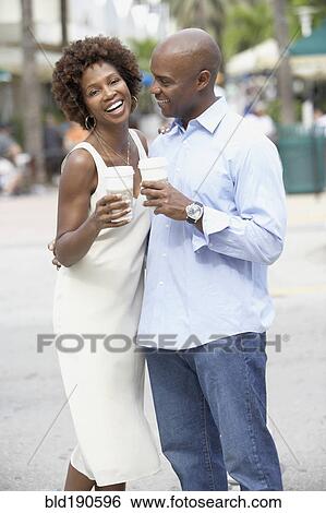 Stock Photograph - African American couple drinking take out coffee. Fotosearch