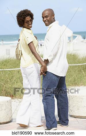 Stock Image - African American couple holding hands. Fotosearch