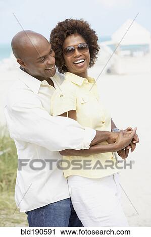Stock Image - African American couple hugging. Fotosearch