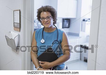 Stock Photo - African American doctor holding digital tablet. Fotosearch