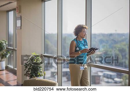 Picture - African American doctor using digital tablet. Fotosearch