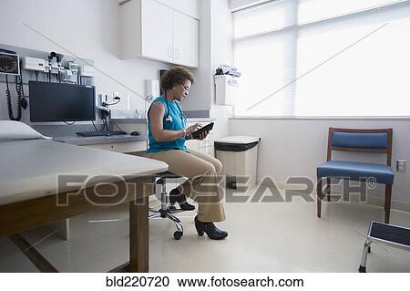 Stock Image - African American doctor using digital tablet. Fotosearch