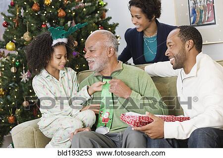 Stock Image - African American family exchanging Christmas gifts. Fotosearch