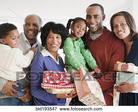 Stock Photo - African American family holding Christmas gifts. Fotosearch