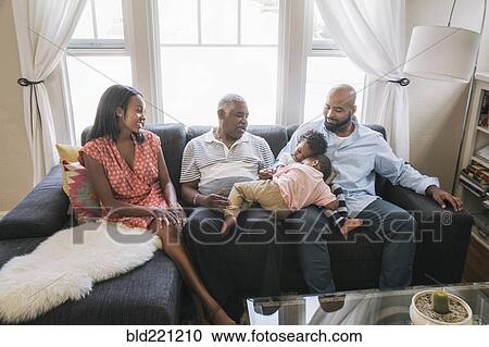 Stock Image - African American family relaxing on sofa. Fotosearch