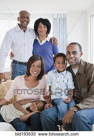 Stock Image - African American family sitting in living room. Fotosearch